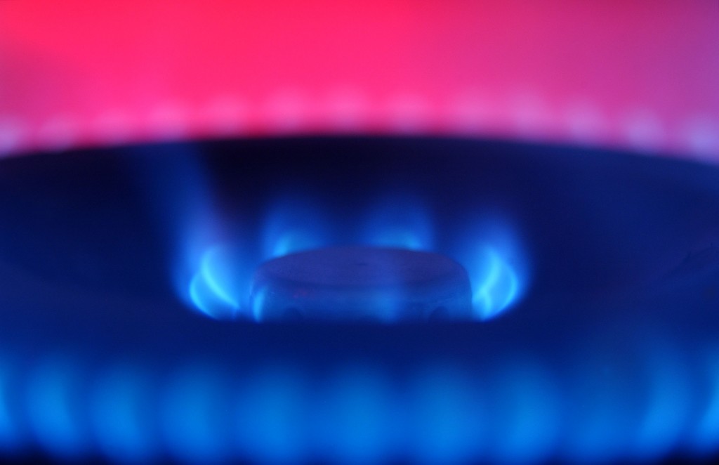 Халява газ. Фон газовая плита с синим пламенем на темной поверхности столешницы.